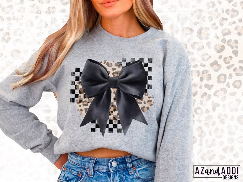 May include: A gray sweatshirt with a black bow and a leopard print design on a checkered background.