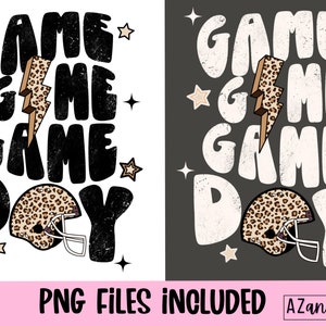 May include: Black and white graphic design with the text "Game Game Game Day" and a football helmet with a leopard print design.