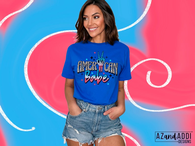 May include: A royal blue t-shirt with a glittery design that says "American Babe" with a peace sign in the middle of the word "American".