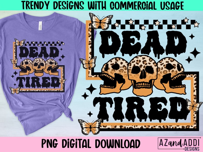 Op de afbeelding: Een paars T-shirt met een grafisch ontwerp van drie schedels met luipaardprint en de tekst "Dead Tired" in zwarte druppelende letters. Het ontwerp is omgeven door een zwart-witte geruite rand met witte sterren.