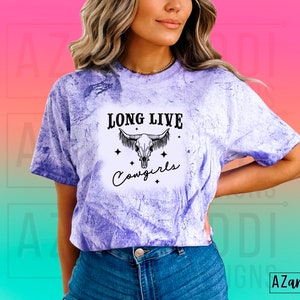 May include: A purple tie-dye t-shirt with a black and white graphic of a cow skull with the text "Long Live Cowgirls".