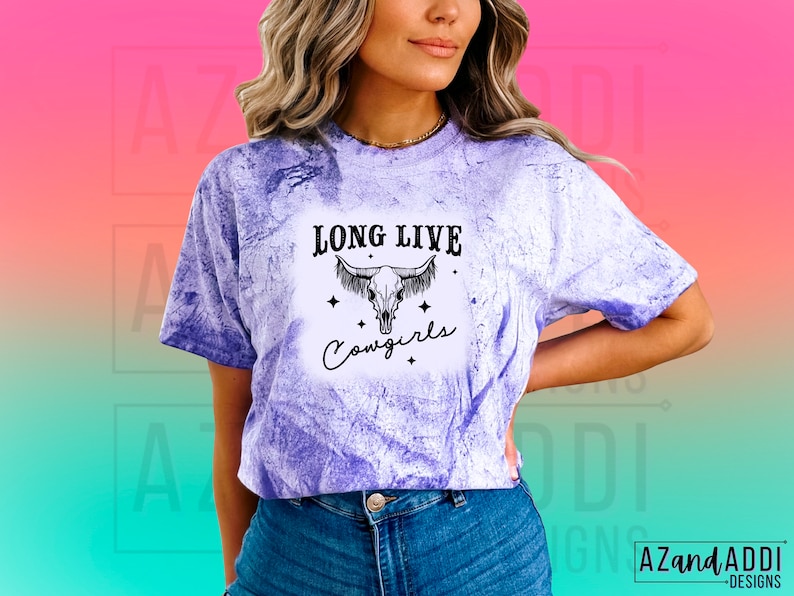 May include: A purple tie-dye t-shirt with a black and white graphic of a cow skull with the text "Long Live Cowgirls".