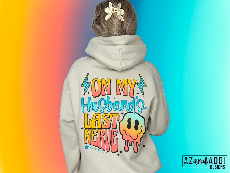 May include: A white hoodie with a colorful graphic on the back that says "On My Husband's Last Nerve" with a dripping smiley face.