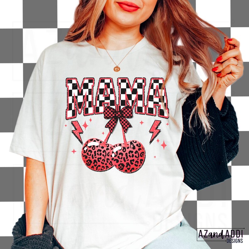 May include: White t-shirt with a black and white checkered "MAMA" graphic with a pink bow and two pink and black leopard print cherries.