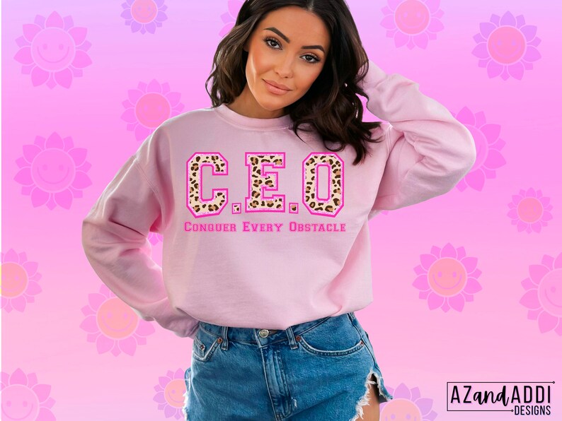 May include: Pink sweatshirt with a leopard print "CEO" graphic and the text "CONQUER EVERY OBSTACLE" in pink.