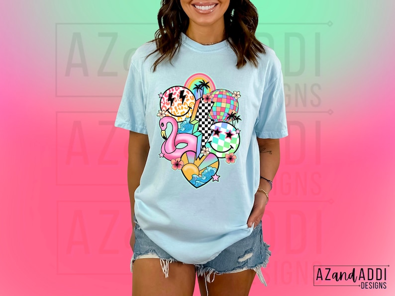 May include: A light blue t-shirt with a colorful graphic print of a flamingo, smiley faces, a disco ball, and other summer-themed elements.