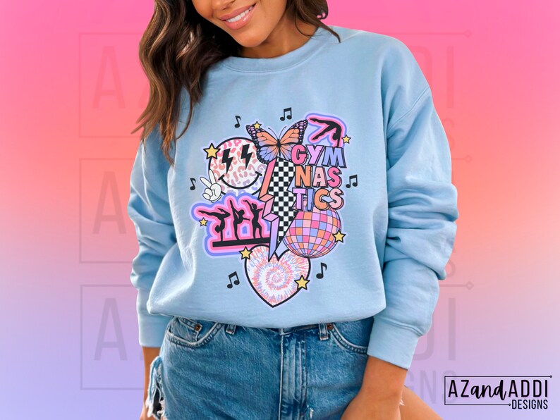 May include: A light blue sweatshirt with a graphic design featuring a butterfly, a disco ball, and the text "Gymnastics".