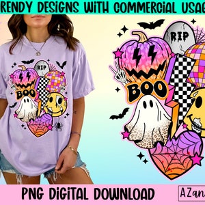 May include: A lilac t-shirt with a Halloween design. The graphic includes a pumpkin, disco ball, ghost, and smiley face, with the word "BOO". The design also features a tombstone and spiderwebs. The text "PNG DIGITAL DOWNLOAD" is visible.
