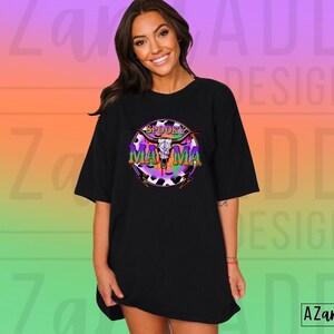 May include: Black t-shirt featuring the text "Spooky Mama" in a colourful graphic with a skull and horns design. The graphic has purple, green, and orange accents. The t-shirt has a relaxed fit.