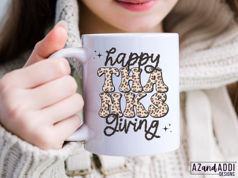 May include: White ceramic mug with a black and brown leopard print design that says "happy THANKS giving" in black text.