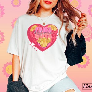 May include: White t-shirt with a pink heart graphic featuring the text "Fries Before Guys" and a cartoon image of french fries.