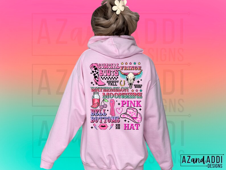 May include: Pink hoodie with a graphic print of a cowgirl wearing fringe boots, a watermelon, moonshine, bell bottoms, and a pink hat. The text on the graphic says "Cowgirl Fringe Boots Howdy Y'all Watermelon Moonshine + Pink Bell Bottoms Hat".