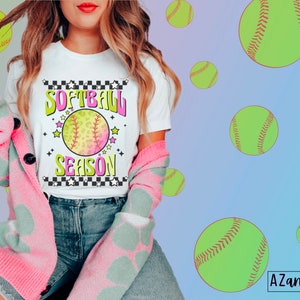 May include: A white t-shirt with a pink and green softball graphic and the text "Softball Season" in a retro style.