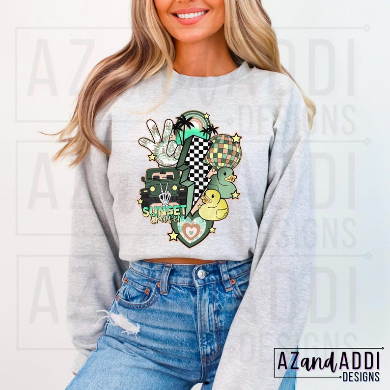 May include: A grey sweatshirt with a graphic design featuring a green jeep, palm trees, a peace sign, a lightning bolt, a disco ball, and rubber ducks. The text "Sunset Craze" is included in the design.
