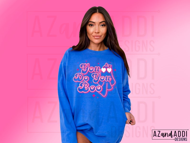K&ouml;nnte beinhalten: Blaues Sweatshirt mit dem Schriftzug "You Do You Boo" in einem verspielten Retro-Schriftstil. Das Design beinhaltet ein Gespenst mit herzf&ouml;rmiger Brille und Schleife. Das Sweatshirt hat eine einfarbige blaue Farbe.