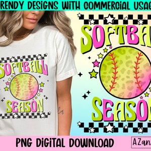 May include: A digital design featuring a softball with a leopard print design and the text "Softball Season" in pink and green letters with a checkered background.