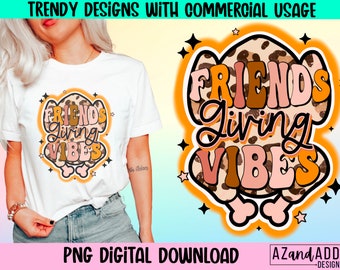 May include: White t-shirt with a colourful graphic that reads "FRIENDS Living VIBES". The design has a leopard print background with orange, brown, and pink lettering. The words are outlined in black and surrounded by stars.