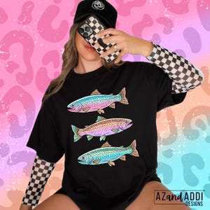 Puede incluir: Camiseta negra con tres ilustraciones de peces coloridos. Cada pez presenta una combinaci&oacute;n de colores &uacute;nica, incluyendo azul, rosa y naranja. La camiseta forma parte de una colecci&oacute;n de ropa con dise&ntilde;os inspirados en la naturaleza.