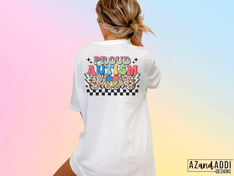May include: White t-shirt with the text "PROUD AUTISM LOVE" in rainbow colors with a checkered pattern and a leopard print heart with a puzzle piece inside.
