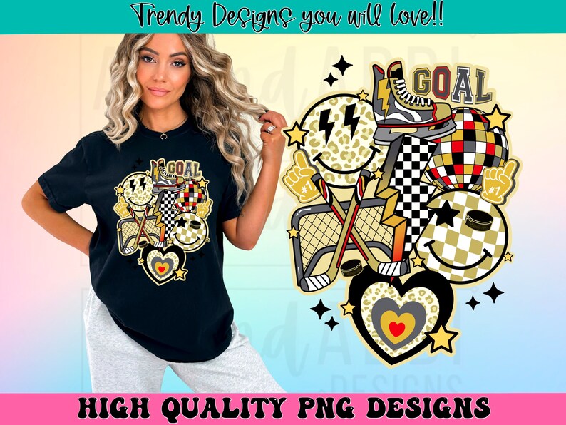 May include: A black t-shirt with a graphic design of a hockey stick, a puck, a heart, and a smiley face with a lightning bolt. The graphic is in a retro style with black, white, gold, and red colors. The text "GOAL" is included in the design.