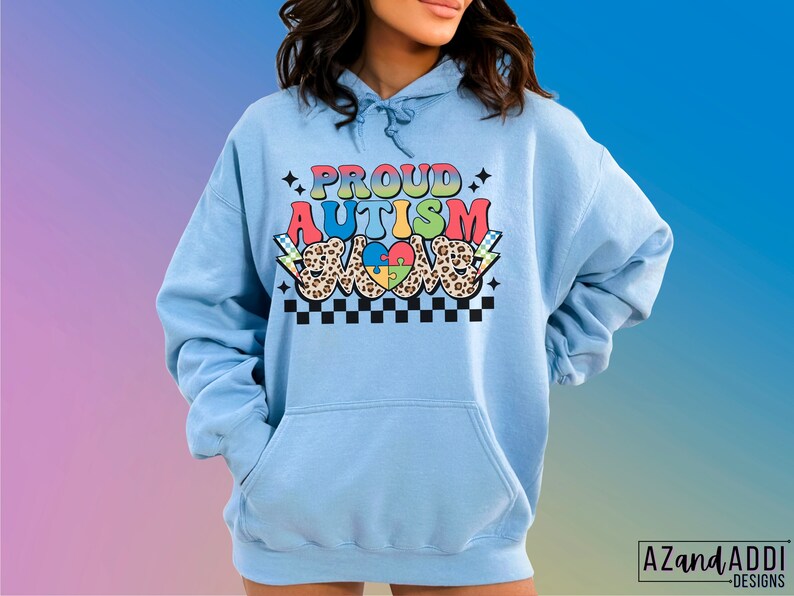 May include: A light blue hoodie with a graphic design that says "Proud Autism Love" in rainbow colors with a puzzle piece heart and leopard print accents.