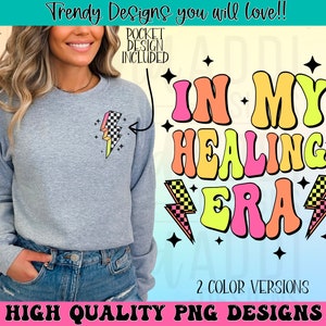 K&ouml;nnte beinhalten: Ein digitales Design mit dem Text "In My Healing Era" im Retro-Stil mit einem Regenbogen-Farbschema. Der Text ist von Blitzen und Sternen umgeben. Das Design ist in zwei Farbversionen erh&auml;ltlich.