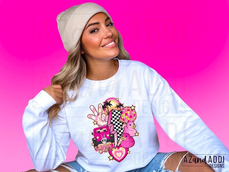 May include: White long-sleeve sweatshirt with a pink and white graphic design featuring a car, palm trees, a peace sign, a disco ball, and the text "Sunset Groovy".