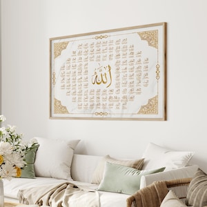 Pode incluir: Uma impressão emoldurada com fundo branco e detalhes dourados. A impressão apresenta a palavra árabe "Allah" no centro, cercada por um círculo de palavras árabes menores. A impressão está pendurada em uma parede branca acima de um sofá com almofadas.