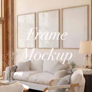 Puede incluir: Tres maquetas de arte enmarcadas con marcos de madera clara cuelgan sobre un sofá blanco y dos sillones. Los marcos tienen un diseño minimalista. El texto "Frame Mockup" está superpuesto en la imagen. También se ven una lámpara y una mesa auxiliar.
