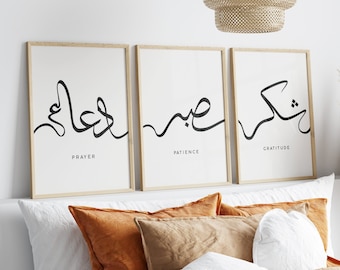 May include: Three framed prints with Arabic calligraphy and English words below. The prints are on a white background with a light wood frame. The words below the calligraphy are "Prayer", "Patience", and "Gratitude".