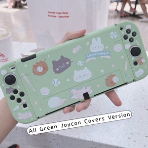 May include: A green Nintendo Switch Joy-Con cover with a baseball theme. The cover features a variety of cute cartoon characters, including a cat, a rabbit, and a baseball player. The text "Championship" and "Baseball" are also featured on the cover.