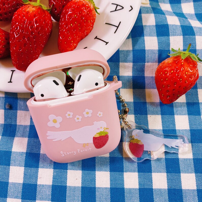 Puede incluir: Una funda rosa para Airpods con un dise&ntilde;o de p&aacute;jaro blanco y el texto "Starry Forest". La funda tiene un peque&ntilde;o charm de fresa.