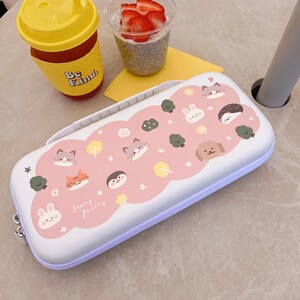 May include: White pencil case with a pink cloud design featuring cartoon animals like cats, a bunny, and a dog. The case has a zipper closure and a handle. The text "Starry Forever" is also visible on the case.