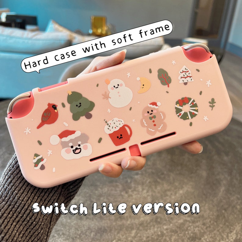K&ouml;nnte beinhalten: Rosa Nintendo Switch Lite H&uuml;lle mit weichem Rahmen. Die H&uuml;lle zeigt ein Winterferien-Thema mit Illustrationen von einem Schneemann, einem Lebkuchenmann und Weihnachtsb&auml;umen.