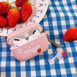 Puede incluir: Funda rosa para Airpods con un dise&ntilde;o de p&aacute;jaro blanco y flores. La funda dice "Starry Forest" y tiene un dije transparente con un p&aacute;jaro blanco y un dise&ntilde;o de fresa roja.