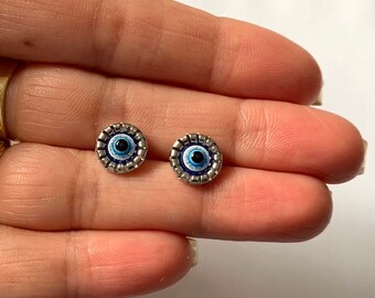 Peut inclure: Une paire de boucles d'oreilles en argent avec un motif d'œil bleu maléfique. Les boucles d'oreilles sont petites et délicates, et seraient un excellent cadeau pour une personne spéciale.