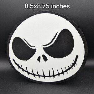 May include: A black and white round sticker featuring the face of Jack Skellington from the movie The Nightmare Before Christmas. The sticker is 8.5x8.75 inches.