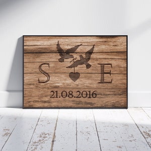 Puede incluir: Un letrero de madera con un acabado rústico marrón que presenta dos palomas con un corazón y las letras "S" y "E" y la fecha "21.08.2016".