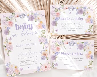May include: A set of baby shower stationery with a floral design. The invitation reads "baby in bloom" and includes details. Accompanying cards include "Books for Baby" and "Diaper Raffle" with floral borders. Soft pastel colors.