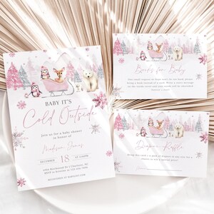 May include: Pink and white baby shower invitation with a winter theme. The invitation features a deer, penguin, and polar bear in a sleigh. The text reads "Baby It's Cold Outside" and includes the date and time of the shower. There are also two smaller cards with the text "Books for Baby" and "Diaper Raffle".