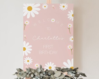 May include: A pink welcome sign with white daisies and the text "Welcome to Charlotte's First Birthday".