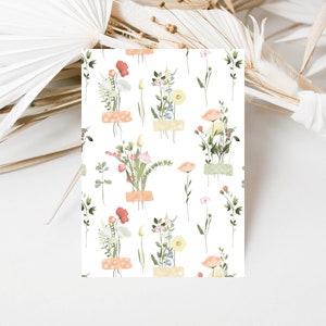 May include: A seamless pattern featuring delicate watercolor illustrations of various wildflowers in shades of pink, orange, yellow, and blue. The flowers are arranged in small bouquets and are tied with a light brown ribbon. The background is white.