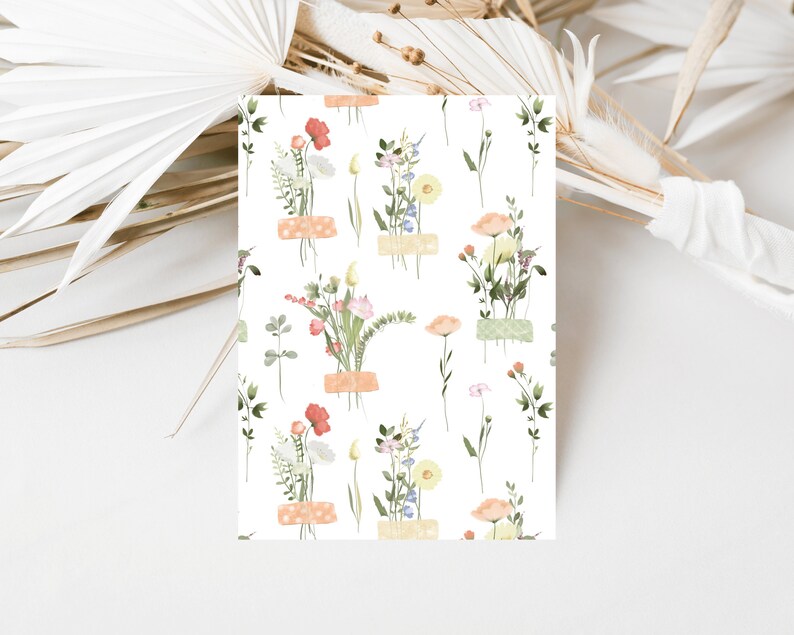 May include: A seamless pattern featuring delicate watercolor illustrations of various wildflowers in shades of pink, orange, yellow, and blue. The flowers are arranged in small bouquets and are tied with a light brown ribbon. The background is white.