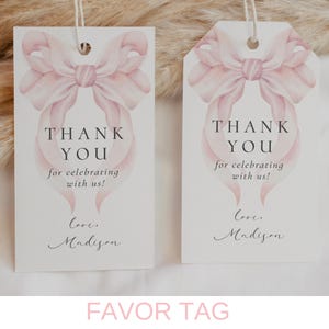 May include: Two white favor tags with a pink watercolor bow design. The text on the tags reads "Thank You for celebrating with us! Love, Madison".