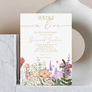 May include: A white bridal shower invitation with a floral border. The invitation reads "WILDLY in love" and includes the text "Join us for a bridal shower honoring Savannah Jackson". The invitation also includes the date, time, location, and RSVP information.