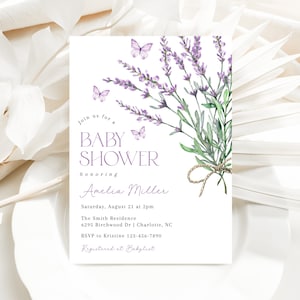 May include: A lavender-themed baby shower invitation with watercolor illustrations of lavender flowers and butterflies. The text reads "Join us for a Baby Shower honoring Amelia Miller. Saturday, August 21 at 2pm. The Smith Residence 6295 Birchwood Dr | Charlotte, NC. RSVP to Kristine 123-456-7890. Registered at Babylist."