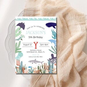 May include: A blue and white invitation card with a sea life theme. The card says "Join us to celebrate JACKSON'S 5th Birthday" and includes details about the party, including the date, time, location, and RSVP information.