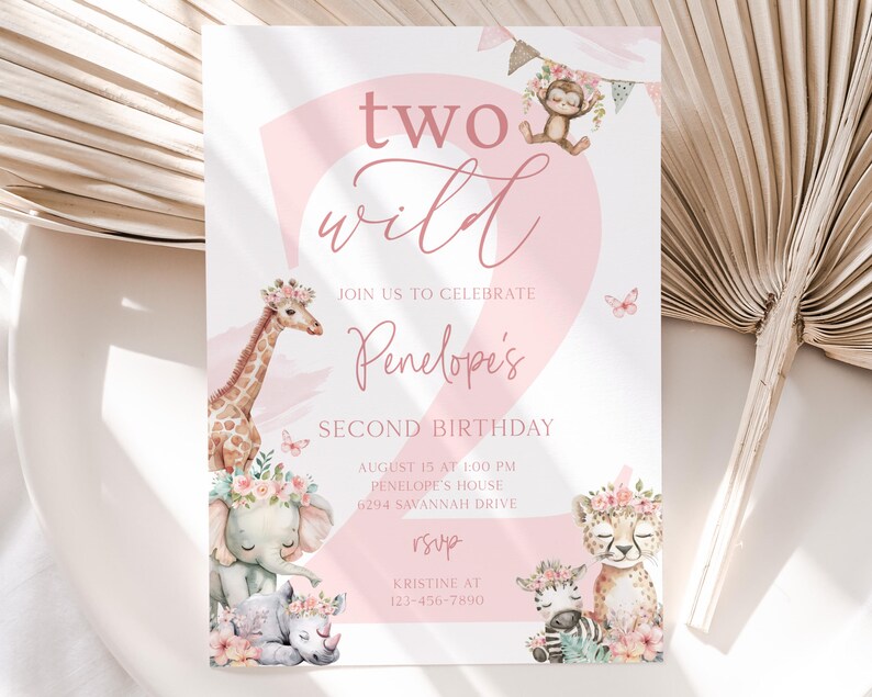 Puede incluir: Invitaci&oacute;n rosa y blanca para una fiesta de segundo cumplea&ntilde;os. El texto dice "two wild" y "Segundo cumplea&ntilde;os de Pen&eacute;lope". La invitaci&oacute;n presenta ilustraciones de una jirafa, un elefante, un guepardo, una cebra y un mono, todos adornados con coronas florales.