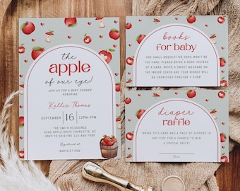 May include: Baby shower invitations with an apple theme. The invitation features the text "the apple of our eye!" with a red apple design. Includes a "books for baby" card and a "diaper raffle" card. A gold wax seal and stamp are also present.