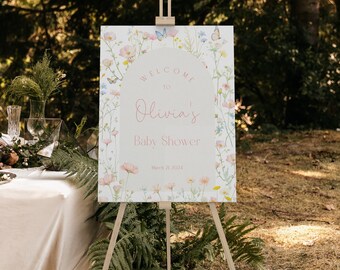 May include: A welcome sign for a baby shower with a floral design and butterflies. The sign says "Welcome to Olivia's Baby Shower March 21, 2024".